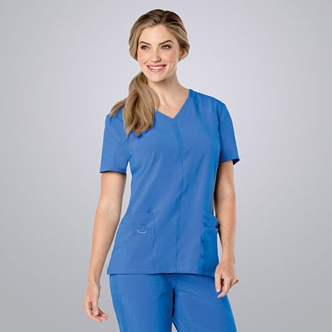 Female nurse wearing blue Landau scrubs against a white background