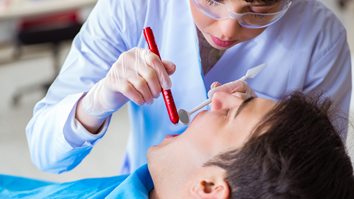 Dentiste examinant la bouche du patient