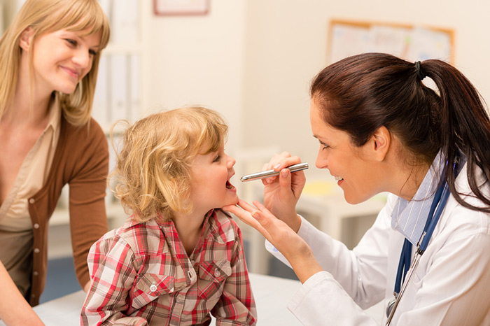 Doctor checking child eyes with penlight