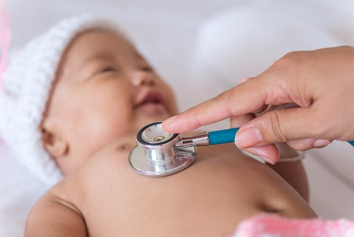 Pediatrician listening to infant chest with stethoscope