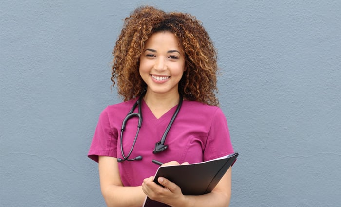 Nurse wearing purple scrubs and black stethoscope
