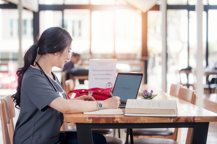 Nurse sits at desk studying