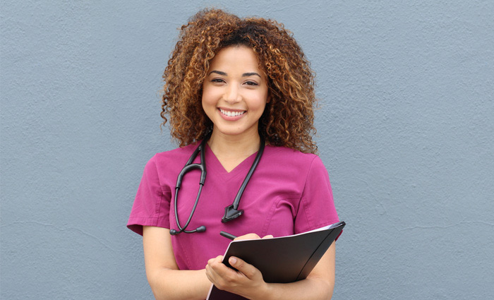 Nurse wearing eggplant colored koi basics scrub top