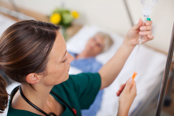 Registered nurse adjusts IV infusion