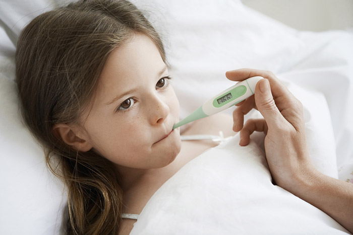 Girl holds thermometer in mouth
