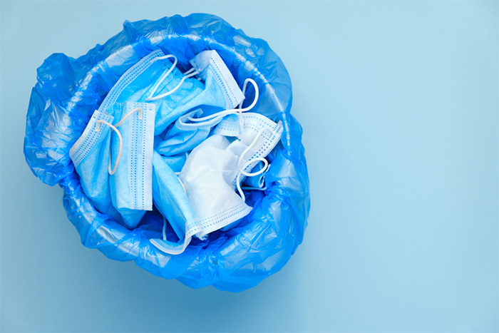 discarded surgical masks in the trash