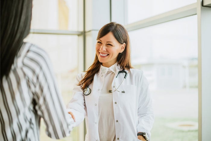 smiling female doctor smiles greets medical sales rep