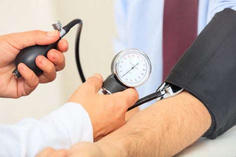 Doctor measuring patient’s blood pressure using a sphygmomanometer