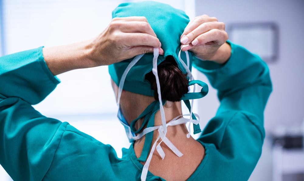 Doctor wearing ponytail scrub cap ties surgical mask