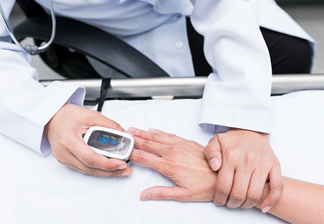 Doctor using an electronic pulse oximeter on a patient