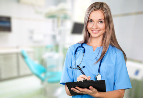 Female nurse smiling while holding clipboard