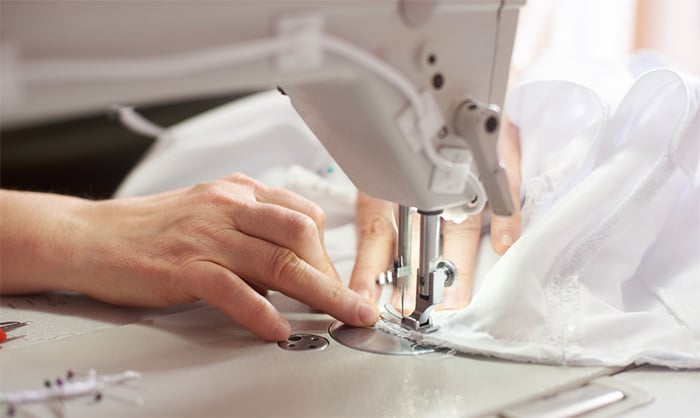 close up of female using sewing machine