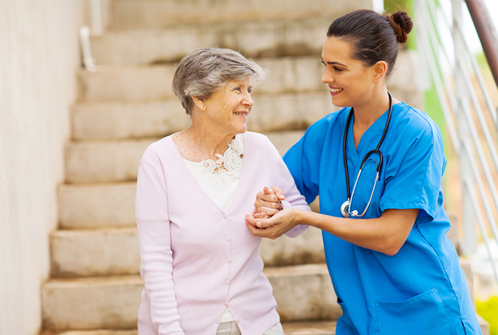 geriatric nurse helping elderly patient