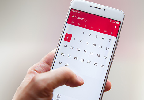 Hand holding a smartphone with a calendar app