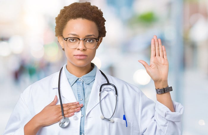 Medical student during white coat ceremony taking Hippocratic oath