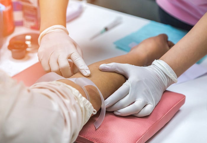 nurse finding patient vein for blood draw