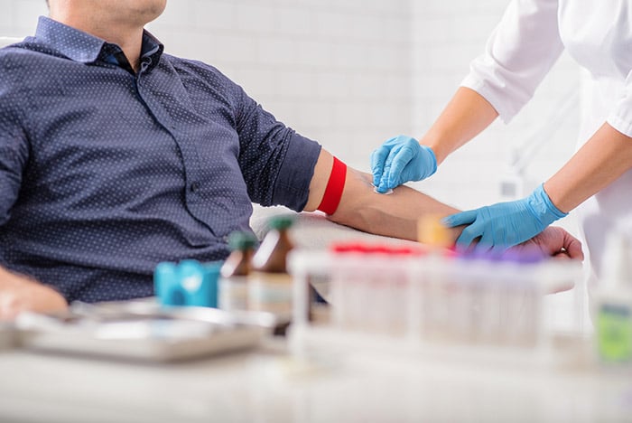 nurse preparing patient arm for drawing blood