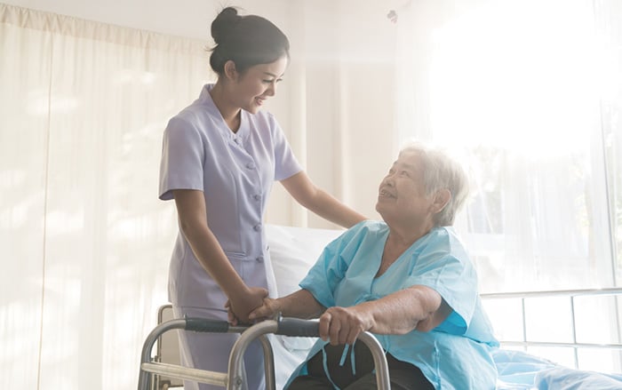 Nurse aid helps female patient in hospital