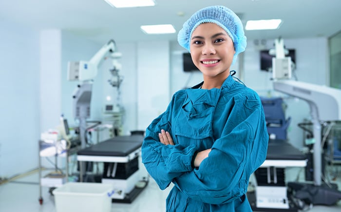 Operating room nurse wears scrubs and disposable surgical cap