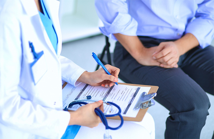 physician assistant sitting with male patient