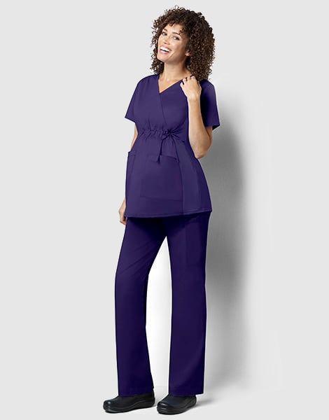 Pregnant female nurse wearing scrubs and smiling