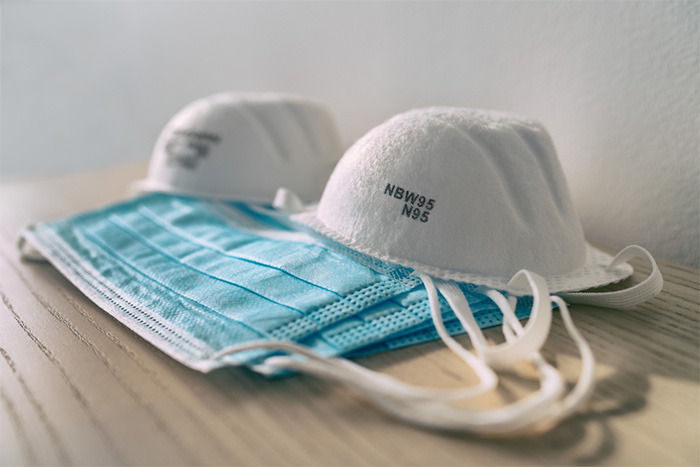 respirator masks and surgical face masks on wooden table