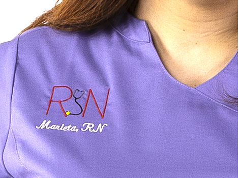 Woman wearing customized medical scrubs with emblem